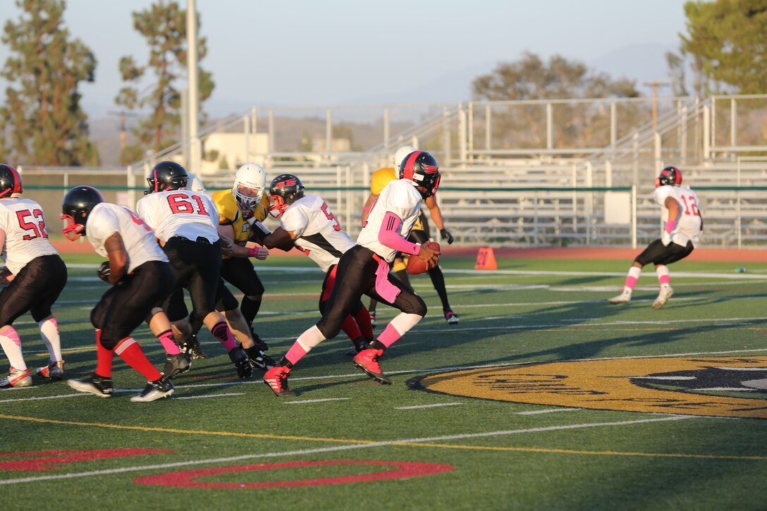 Lance Cpl. Jabari Moore, Marine Corps Air Station Miramar Falcons’ quarterback, rolls out of the pocket during a football game against the 1st Marine Logistics Group Beasts at Paige Fieldhouse aboard Marine Corps Base Camp Pendleton, Calif., Oct. 14. The Falcons will start the playoffs next week in their quest to become the “Best in the West.”