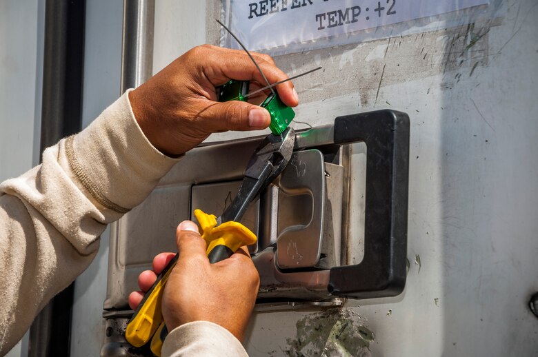 A seal on a conveyance truck filled with food supplies for members of the 386th Air Expeditionary Wing is cut prior to inspection by food inspectors from the Army Public Health Command. The food inspectors’ primary mission is to reduce the risks to public health associated with diseases and other health hazards in food that is designated for more than 3,000 Airmen, Soldiers, Marines, Sailors and contractors. (U.S. Air Force photo by Senior Master Sgt. Allison Day)