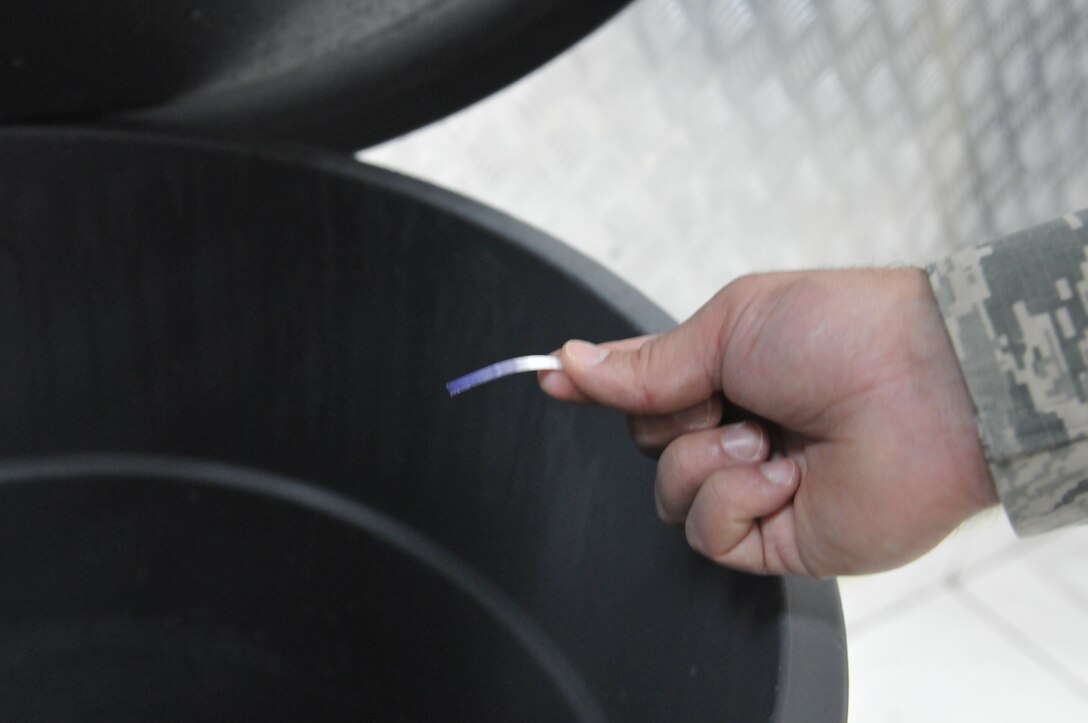 Air Force Staff Sgt. James Rodenberg, 386th Expeditionary Medical Group public health technician uses a test strip to test a mix of bleach water which is used to kill microorganisms on food contact surfaces at the main dining facility at The Rock Sept. 23, 2014. If the solution is too weak, it will not kill the microorganisms and if it’s too strong, it can make people sick. Rodenberg conducts inspections two times each month at both dining facilities to promote good personal hygiene across the base and to ensure that facilities are operating in accordance with governing regulations. He deployed from 96th Aerospace Medicine Squadron Eglin Air Force Base, Fla., in support of Operation Enduring Freedom and is a native of Crestview, Fla. (U.S. Air Force photo by Senior Master Sgt. Allison Day)