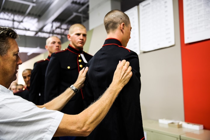 A recruit of Echo Company, 2nd Recruit Training Battalion, stands while the tailor alters his dress blue coat at Marine Corps Recruit Depot San Diego, Oct. 1. Recruits will wear the uniform once they earn the title Marine. 