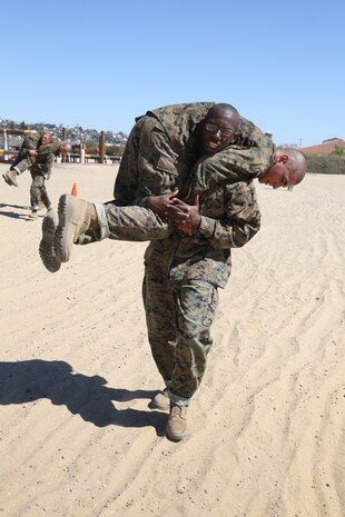 A Company A recruit uses the fireman’s carry to move a simulated
casualty out of harm’s way after completing the depot’s obstacle
course. After the recruits finished the eight obstacles in the course,
they were required to perform the buddy drag and the carry to complete
the event.