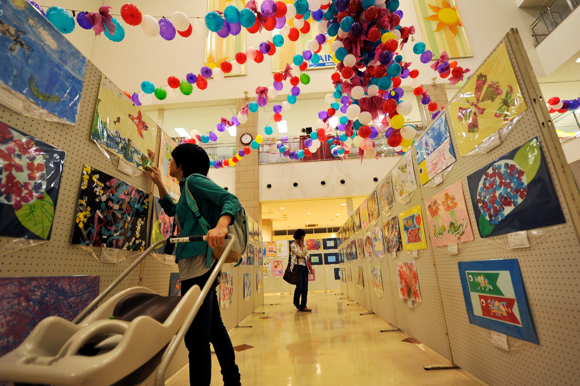 Guests enjoy the Kadena Special Olympics art exhibit at Main City Shopping Mall San-A in Uruma City, Oct. 16, 2014. The art exhibit ran from Oct. 16-19 from 9 a.m. to 7 p.m. each day and is open to the public. The purpose of the event is to support special needs individuals for their talent and effort through this art exhibit and sporting events to be held on Kadena Air Base in November. (U.S. Air Force photo by Naoto Anazawa/Released)