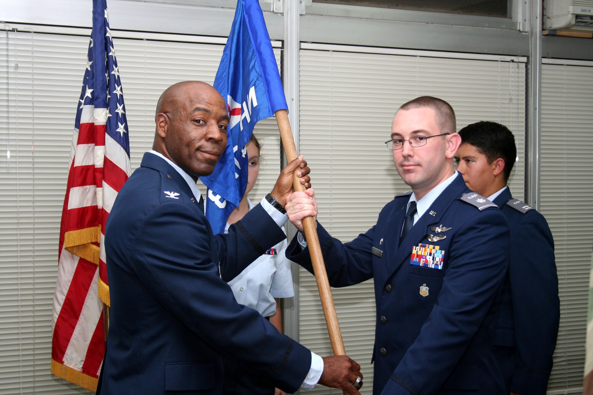 Col. Clarence Lukes, 374 Airlift Wing Vice Commander, hands the guidon to Civil Air Patrol Lt Col Adam Boyd as Boyd assumes command of the Yokota Cadet Squadron, NHQ 103, at Yokota Air Base, Japan on October 9, 2014. The Civil Air Patrol is the official auxiliary of the U.S. Air Force, established in 1948. (Courtesy photo by Billie Thompson/released)