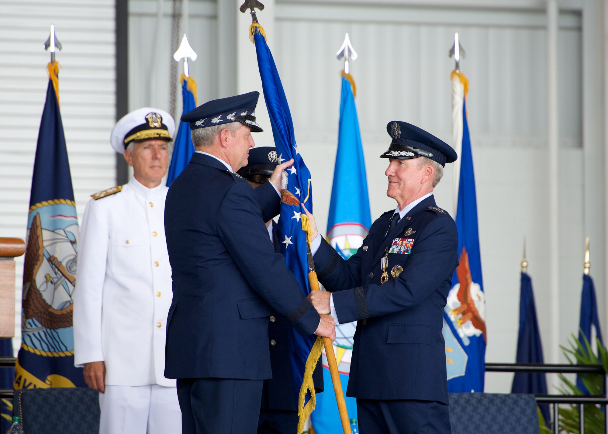 Gen. Hawk Carlisle, outgoing Pacific Air Forces commander, relinquishes the PACAF flag to Air Force Chief of Staff Gen. Mark A. Welsh III during the PACAF change of command ceremony at Joint Base Pearl Harbor-Hickam, Hawaii, Oct. 16, 2014. Gen. Lori Robinson became the first woman to lead a U.S. Air Force Component Major Command when she succeeded Carlisle during the ceremony. (U.S. Air Force photo by Capt. Raymond Geoffroy/Released)
