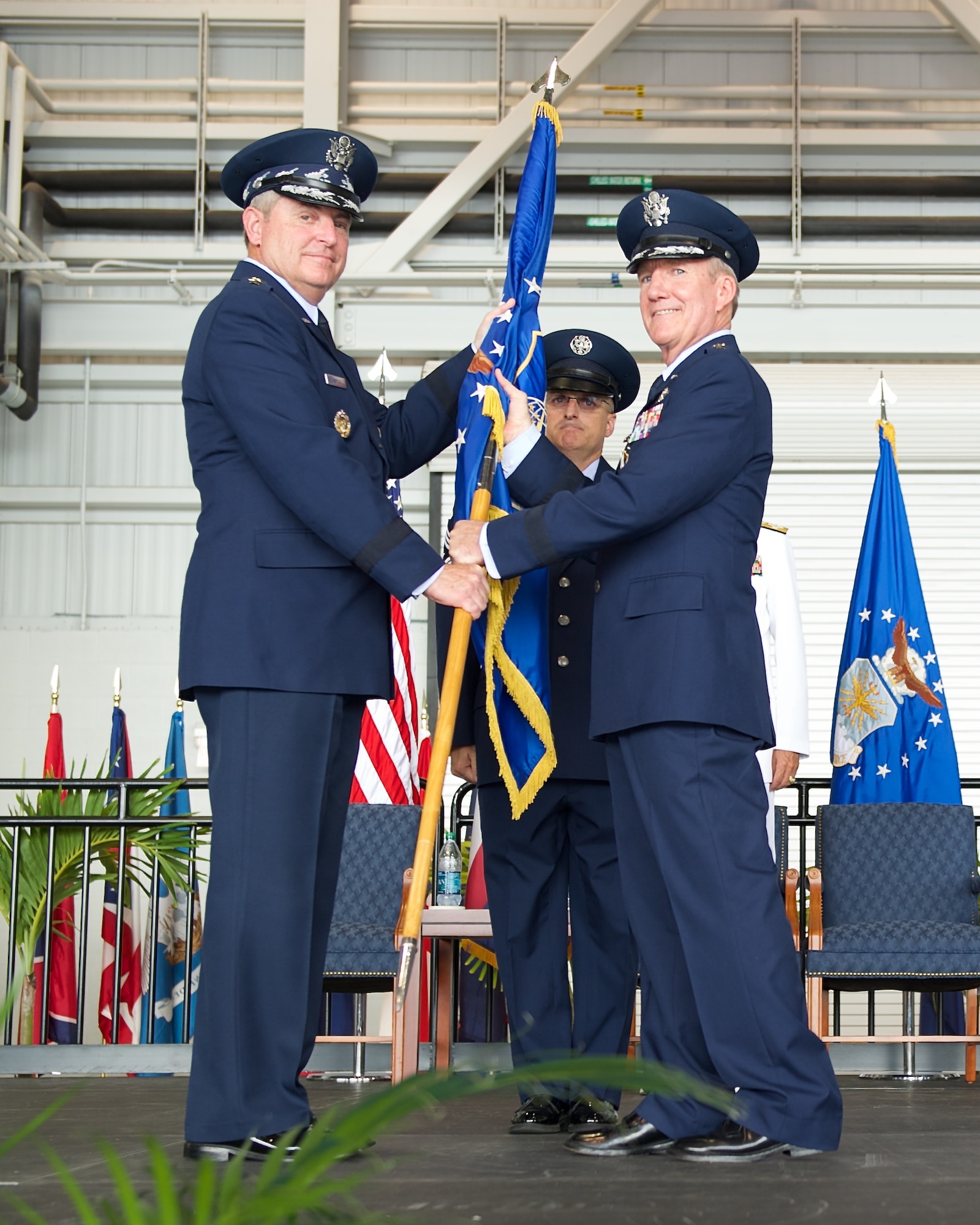 Gen. Hawk Carlisle, outgoing Pacific Air Forces commander, relinquishes the PACAF flag to Air Force Chief of Staff Gen. Mark A. Welsh III during the PACAF change of command ceremony at Joint Base Pearl Harbor-Hickam, Hawaii, Oct. 16, 2014. Gen. Lori Robinson became the first woman to lead a U.S. Air Force Component Major Command when she succeeded Carlisle during the ceremony. (U.S. Air Force photo by Tech. Sgt. James Stewart/Released)