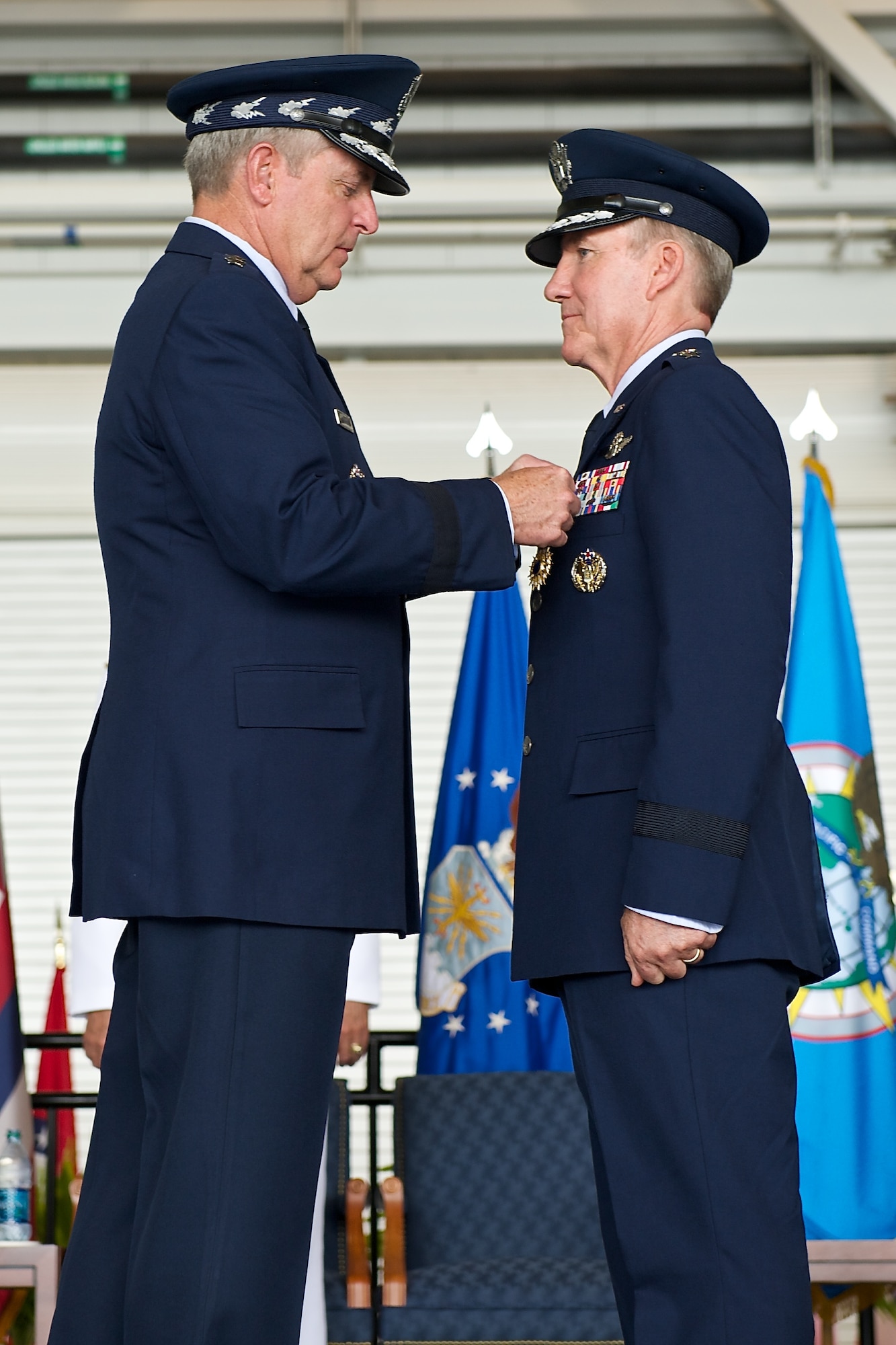 Air Force Chief of Staff Gen. Mark A. Welsh III presents Gen. Hawk Carlisle, outgoing Pacific Air Forces commander, with a Distinguished Service Medal during the PACAF change of command ceremony at Joint Base Pearl Harbor-Hickam, Hawaii, Oct. 16, 2014. Gen. Lori Robinson succeeded Carlisle during the ceremony. (U.S. Air Force photo by Tech. Sgt. James Stewart/Released)