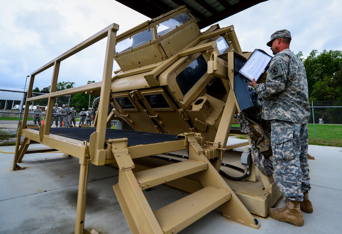 U.S. Army Staff Sgt. Edward Clarke, 53rd Transportation Battalion (Movement Control), 7th Transportation Brigade (Expeditionary) cargo specialist, monitors Soldiers as they perform Humvee rollover training at Fort Eustis, Va., Oct. 15, 2014. The 53rd Trans. Btn. (MC) specializes in the movement of Soldiers, equipment and other critical assets to deployed locations. (U.S. Air Force photo by Senior Airman Kayla Newman/Released)