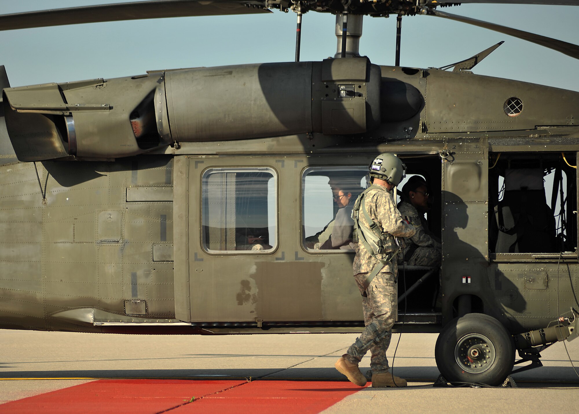 A Minnesota Army National Guard 34th Combat Aviation Brigade member prepares 319th Operations Support Squadron members for a familiarization flight in a UH-60 Blackhawk Oct. 10, 2014 on Grand Forks Air Force Base, N.D. The familiarization flight was for members who work on or around the airfield to broaden their understanding of the scope of the mission. (U.S. Air Force photo/Senior Airman Xavier Navarro)