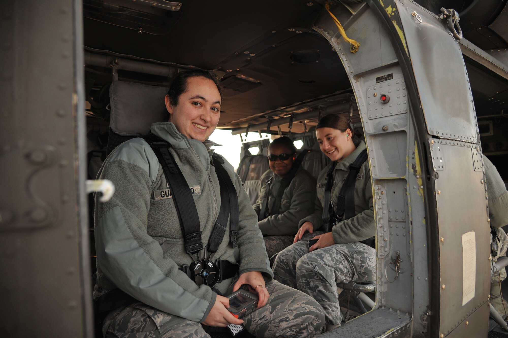 Senior Airman Sara Guajardo, 319th Operations Support Squadron airfield management shift leader, Senior Airman Rae Steichen, 319th OSS weather forecaster and Airman 1st Class Iteria Walker, 319th OSS airfield management apprentice, wait to take off on a familiarization flight from Grand Forks Air Force Base, N.D., Oct. 10, 2014. Members of the 319th OSS got a chance to ride along in a UH-60 Blackhawk in order to help foster rapport between the two units. (U.S. Air Force photo/Senior Airman Xavier Navarro) 