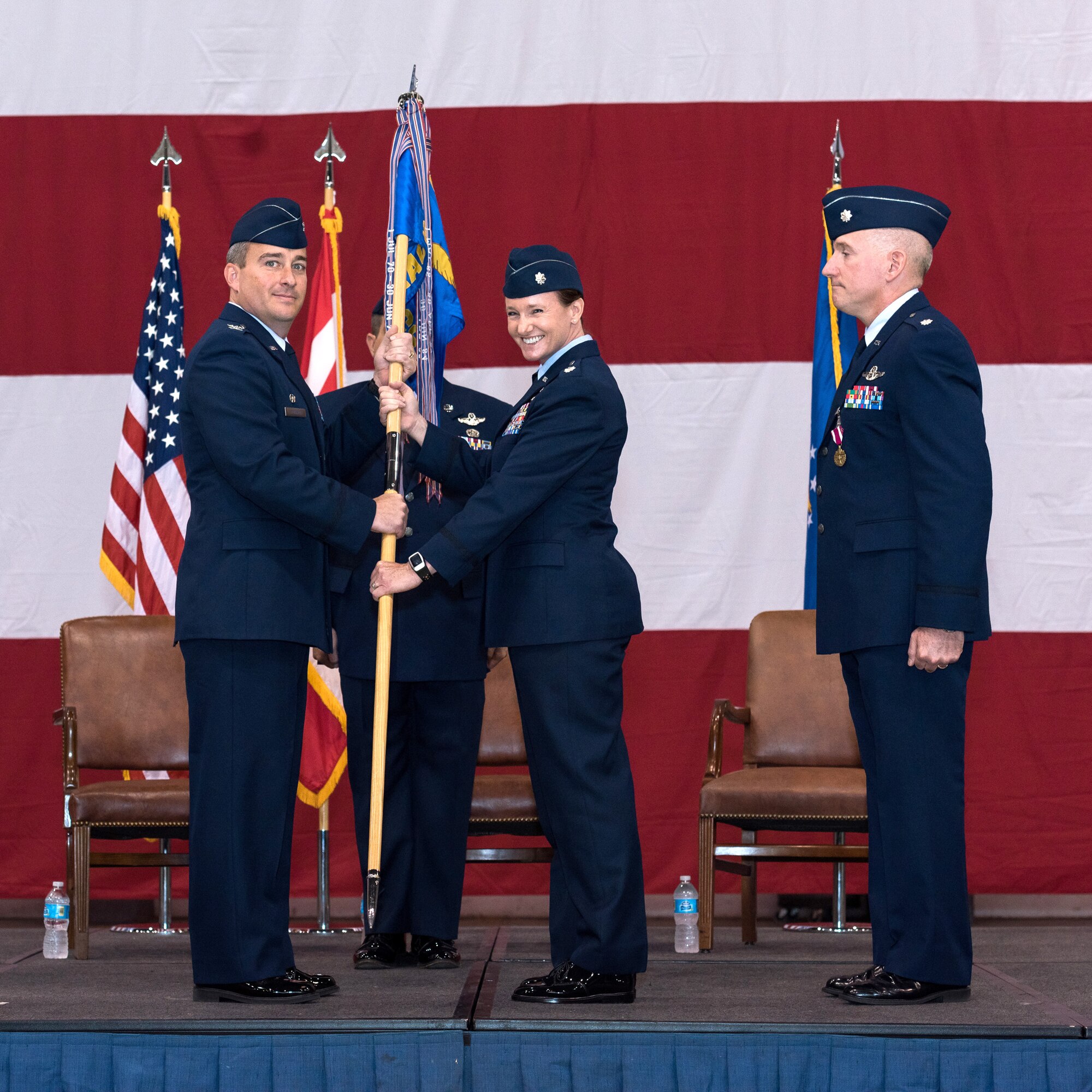 Lt. Col. Carol O’Neil, center, is all smiles as she accepts the guidon from Col. Alain Poisson, 552nd Operations Group commander, shortly after assuming command of the 965th Airborne Air Control Squadron during a ceremony Oct. 2 in Bldg. 230, Dock 2. Colonel O’Neil replaces Lt. Col. Anthony Kleiger, right, who will be headed to United States Pacific Command at Camp Smith, Hawaii, to work in operations there. Colonel O’Neil had previously served as the 552nd Air Control Wing director of staff. Colonel Poisson presided over the ceremony attended by a host of family, friends and co-workers. (Air Force photo by Staff Sgt. Kristopher Gooden)