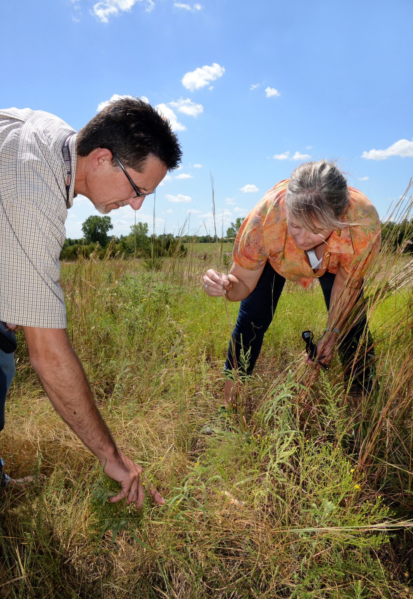 John Krupovage, Natural Resources manager with the 72nd Civil Engineering Directorate, and Dr. Karen Hickman, professor of Natural Resource Ecology and Management at Oklahoma State University and president of the Oklahoma Invasive Plant Council, find invasive blue stem prairie grasses around the Scissortail Trail area of Tinker Air Force Base. Dr. Hickman and her team are helping the Tinker Environmental Management Directorate on a DOD-funded five-year project to kill invasive (non-native) grasses and to restore native prairie grasses to the urban greenway. (Air Force photo by Kelly White)