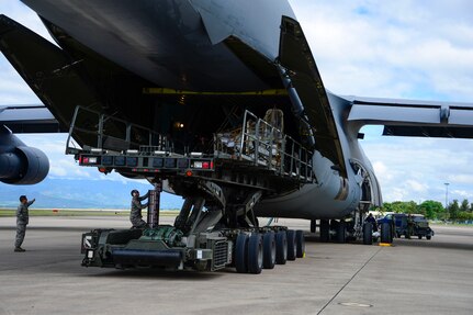 Crew members of a C-5 Galaxy from Westover Air Reserve Base, Mass., and members from the 612th Air Base Squadron unload a shipment of donated goods at Soto Cano Air Base, Honduras, Oct. 11, 2014.  The cargo transporting aircraft delivered over 6,000-pounds of humanitarian aid and supplies that were donated to Honduran citizens in need through the Denton Program.  The Denton Program allows private U.S. citizens and organizations to use space available on U.S. military cargo planes to transport humanitarian goods to approved countries in need. (U.S. Air Force photo/Tech. Sgt. Heather Redman)