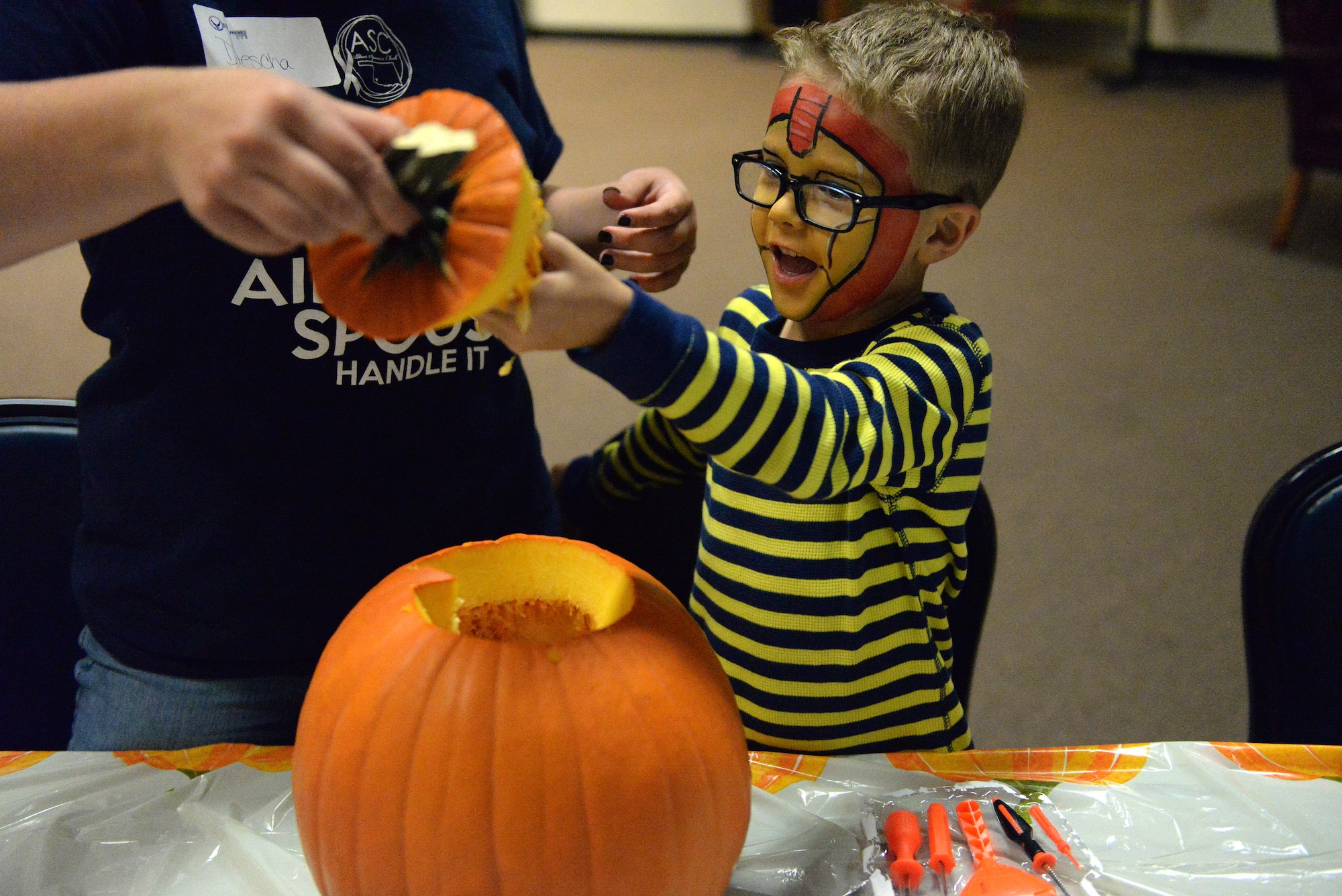 ALTUS AIR FORCE BASE, Okla. – A child pulls seeds off the lid of his pumpkin with his mother at the deployed family dinner at the Freedom Community Center, Oct. 14, 2014. The Deployed Family Dinner is held every quarter and often includes activities to match the season. Last year, during a holiday deployed family dinner, toys were given to the children in attendance. (U.S. Air Force photo by Airman 1st Class Megan E. Acs/Released)