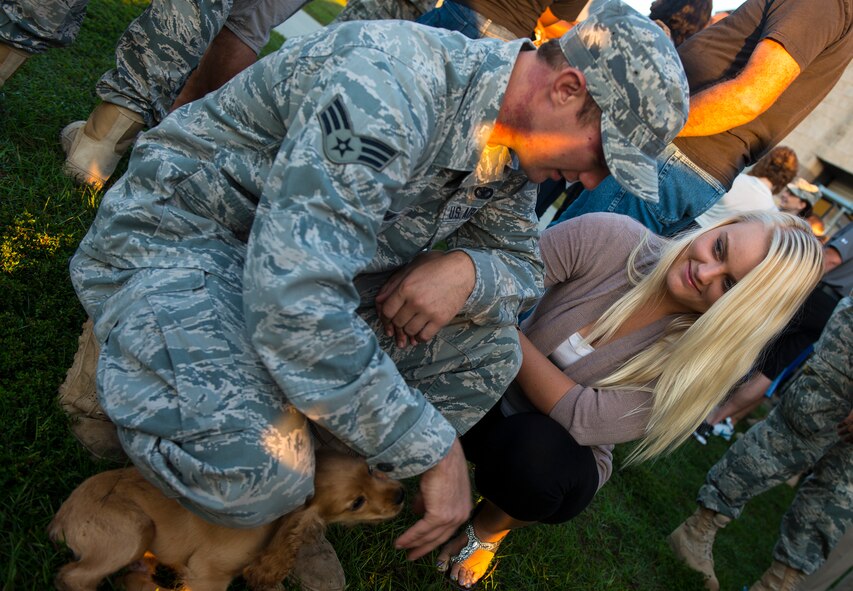 U. S. Air Force Senior Airman Justin Guin, 822d Base Defense Squadron and girlfriend Courtney  share a few last moments with their dog before Guin’s  deployment Oct. 12, 2014, at Moody Air Force Base, Ga. Guin gave Courtney the dog as a companion during their first deployment as a couple. (U.S. Air Force photo by Airman 1st Class Ceaira Tinsley/Released)