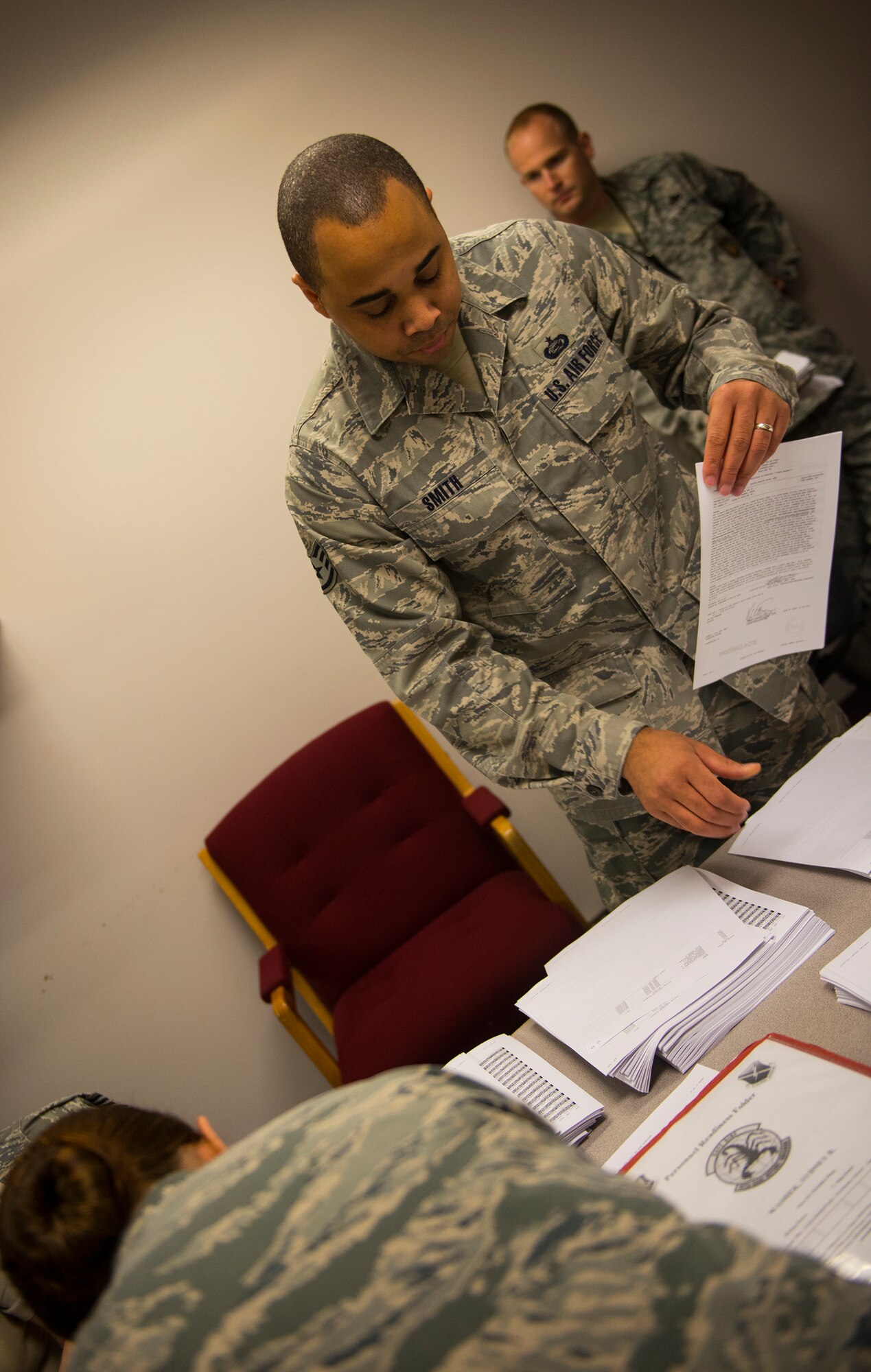 U.S. Air Force Staff Sgt. Travis Smith, 23d Force Support Squadron NCO in charge of installation personnel, sorts through orders for Airmen during a deployment line Oct. 8, 2014, at Moody Air Force Base, Ga. Approximately 165 Airmen left Moody for a six-month deployment to Southwest Asia. (U.S. Air Force photo by Airman 1st Class Ceaira Tinsley/Released)