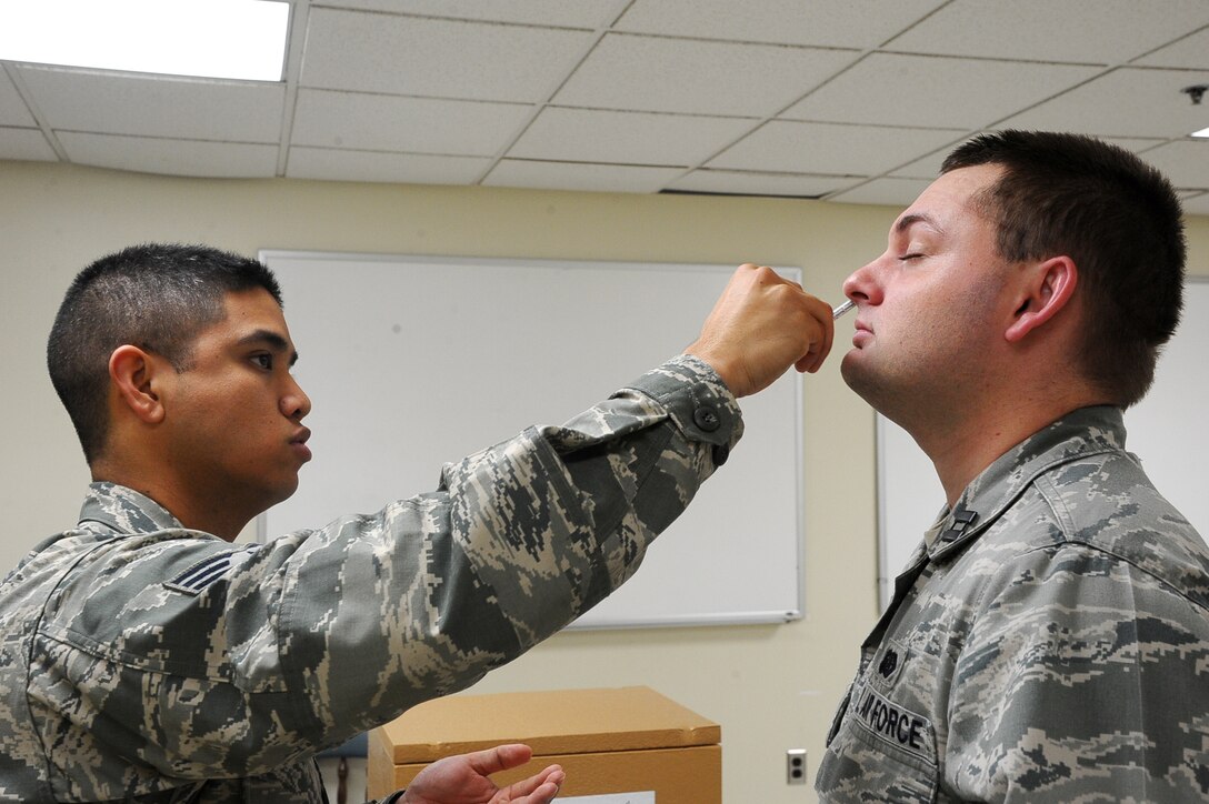 Senior Airman Robert Carino, 14th Medical Operations Squadron, administers a flu mist vaccine to Capt. Fredrik Poole, 14th Mission Support Group, Oct. 16 at the Walker Center. These are mandatory for military members as it is the best way to prevent Flu. (U.S. Air Force photo/Airman Daniel Lile)