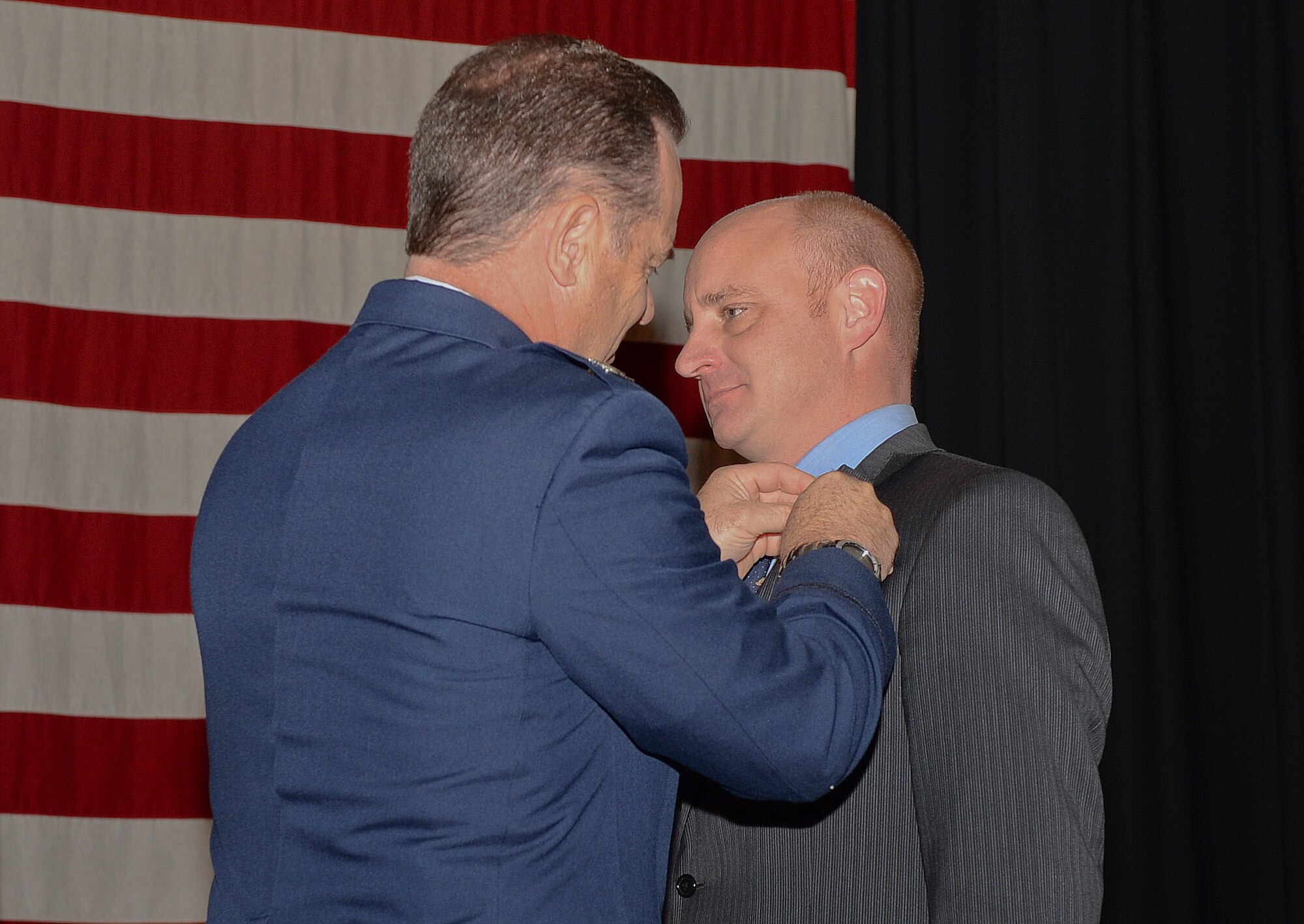 James Havers-Strong, ABI Group of Companies CEO and managing director, receives an Honorary Commander pin from Col. Mark S. Larson, 931st Air Refueling Group Commander, during an Honorary Change of Command ceremony here, Oct. 15, 2014. The Honorary Commander Program is a joint venture between the active duty 22nd Air Refueling Wing and the Reserve 931st ARG. The program pairs local community leaders with unit commanders in order to foster strong relationships between McConnell Air Force Base and civilian leaders. (U.S. Air Force photo by Airman 1st Class Colby Hardin)