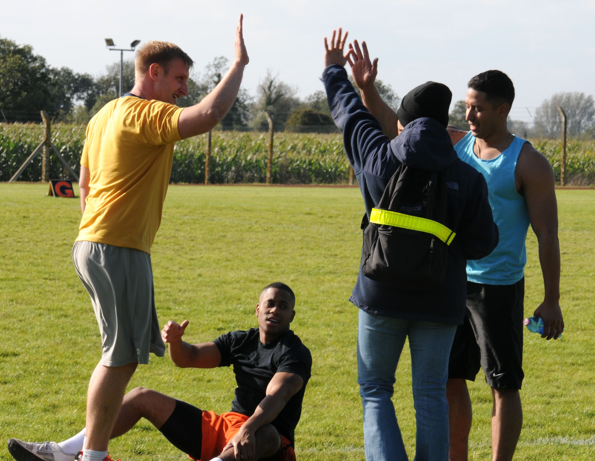 U.S. Air Force members assigned to RAF Mildenhall and RAF Lakenheath high-five as they complete the final event during a Combined Federal Campaign Fitness Challenge Oct. 9, 2014, at Heritage Park on RAF Mildenhall, England. The event promoted healthy competition, improved fitness levels and raised money for charities across the U.S. (U.S. Air Force photo/Gina Randall/Released)
