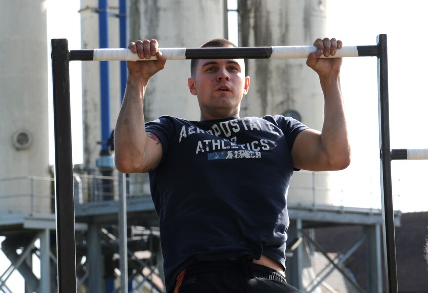 A U.S. Air Force member takes part in a pull-up competition during a Combined Federal Campaign Fitness Challenge Oct. 9, 2014, at Heritage Park on RAF Mildenhall, England. The events included relay races, burpees, a tire flip, low crawl, 500 lb transfer, sit-ups, pull-ups and body drag. (U.S. Air Force photo/Gina Randall/Released)