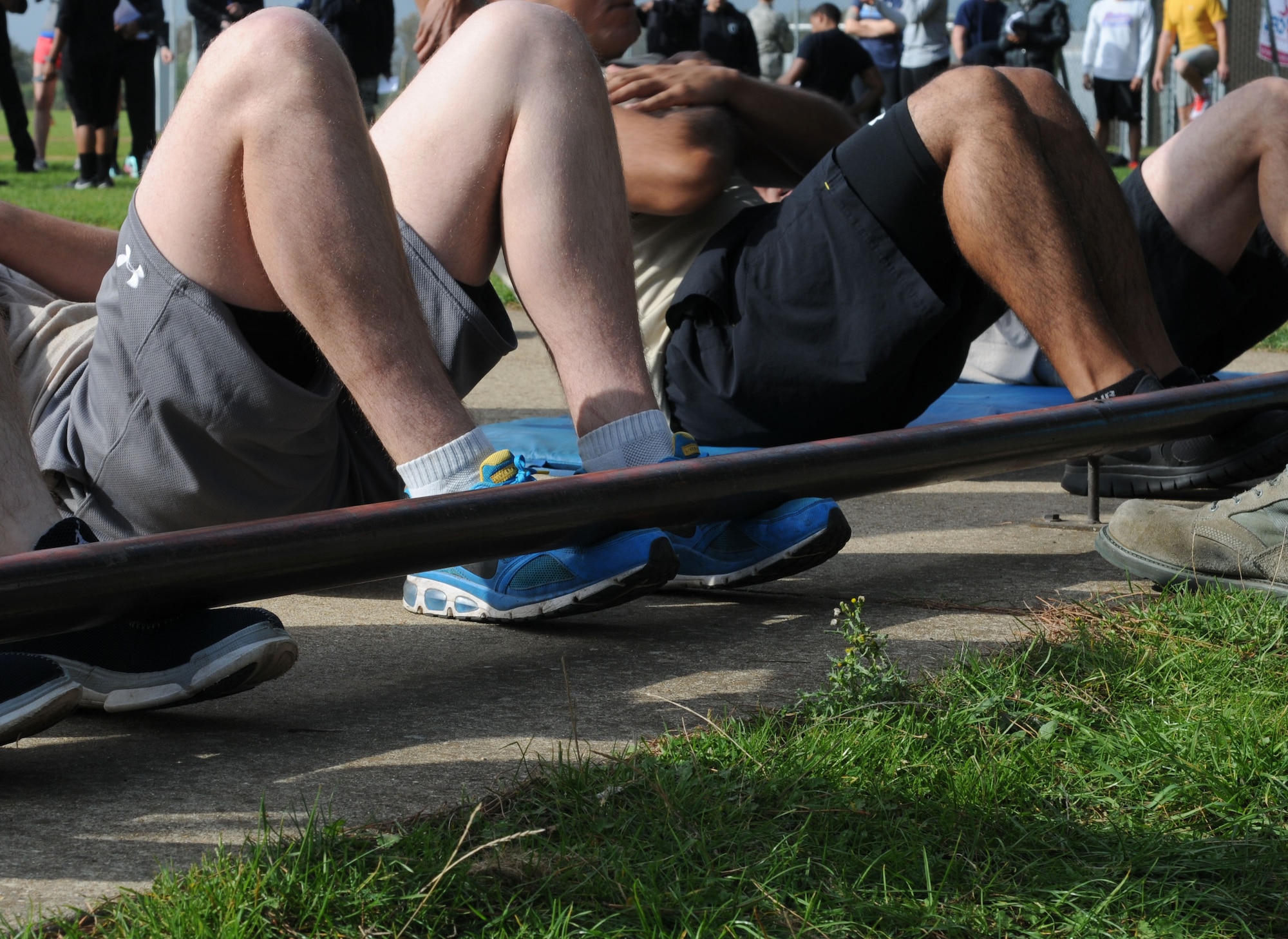 U.S. Air Force members assigned to RAF Mildenhall and RAF Lakenheath perform sit-ups during the Combined Federal Campaign Fitness Challenge Oct. 9, 2014, at Heritage Park on RAF Mildenhall, England. The event promoted healthy competition and fitness while raising money for charities across the U.S. (U.S. Air Force photo/Gina Randall/Released)