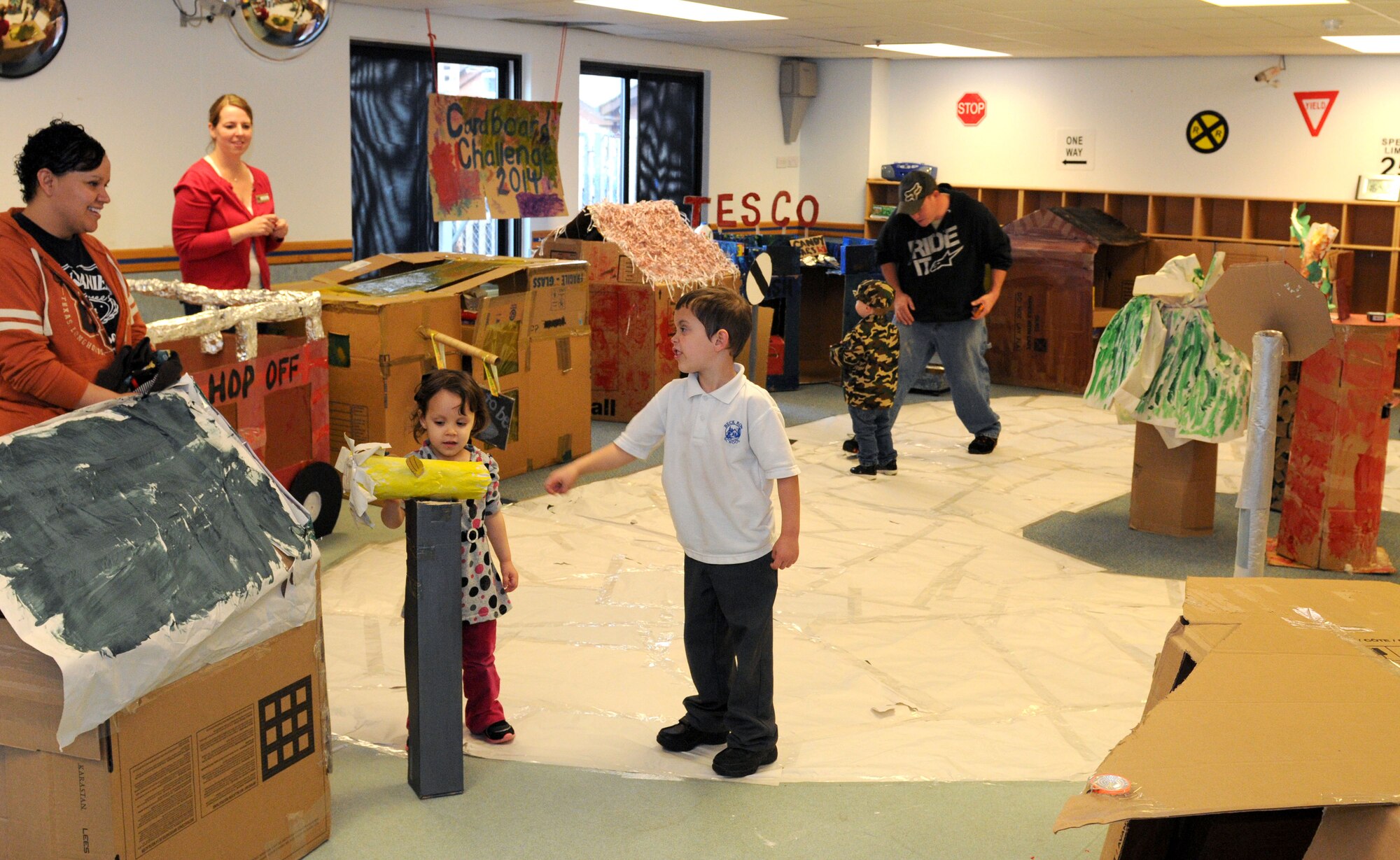U.S. Air Force Airmen and their children explore a cardboard English village in preparation for the Global Cardboard Challenge Oct. 10, 2014, at the Child Development Center on RAF Mildenhall, England. This year is the 3rd annual Global Cardboard Challenge presented by the Imagination Foundation that invites children and their communities to foster creativity and teamwork by building items to mind out of cardboard, recycled materials and their imagination. (U.S. Air Force photo/Senior Airman Kate Maurer/Released)