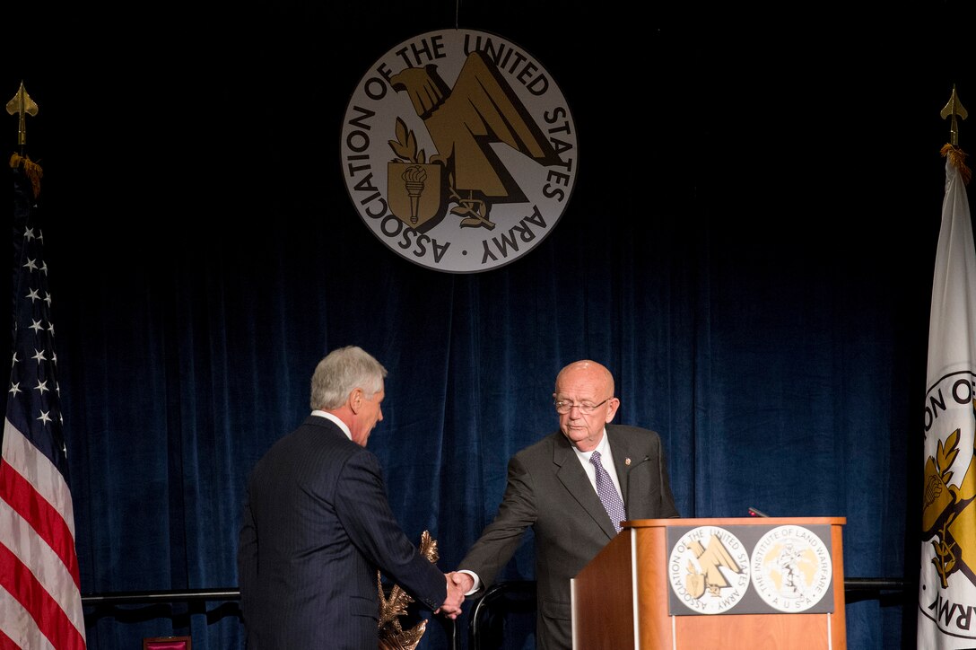 Retired Army Gen. Gordon Sullivan, right, shakes hands with Defense Secretary Chuck Hagel after introducing him as the guest speaker at the Association of the United States Army Conference at the Walter E. Washington Convention Center in Washington D.C., Oct. 15, 2014.