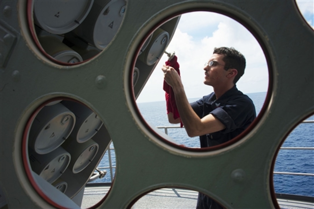 U.S. Navy Petty Officer 2nd Class Miguel Moreno performs maintenance on a Rolling Airframe Missile System on the flight deck of the aircraft carrier USS George Washington in the Sulu Sea, Oct. 16, 2014.