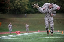 Futures Directorate Deputy Director, Colonel Jeff Holt performs a fireman carry during the Maneuver Under Fire portion of the Combat Fitness Test