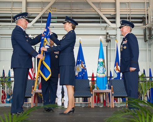 Gen. Hawk Carlisle, outgoing Pacific Air Forces commander, relinquishes the PACAF flag to Air Force Chief of Staff Gen. Mark A. Welsh III during the PACAF change of command ceremony Oct. 16, 2014, at Joint Base Pearl Harbor-Hickam, Hawaii. Gen. Lori Robinson became the first woman to lead a U.S. Air Force Component Major Command when she succeeded Carlisle during the ceremony. (U.S. Air Force photo/Tech. Sgt. James Stewart)