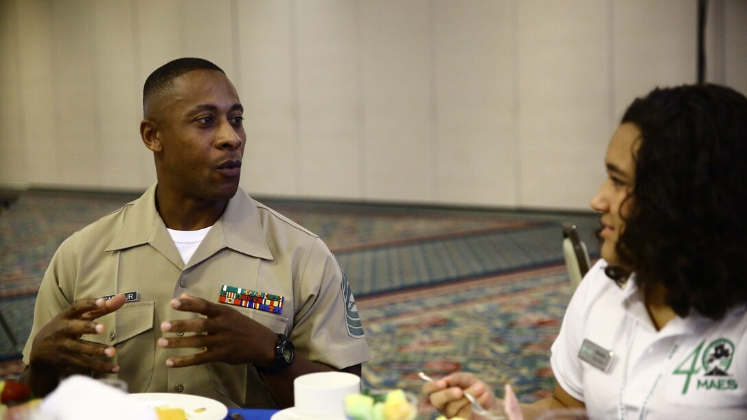 Master Sgt. Mark McArthur, Diversity Chief, Marine Corps Recruiting Command, speaks with a MAES member during the Industry Advisory Council meeting and partners breakfast, here, today. The mission of MAES is to promote, cultivate, and honor excellence in education among engineers and scientist of Latin American descent.