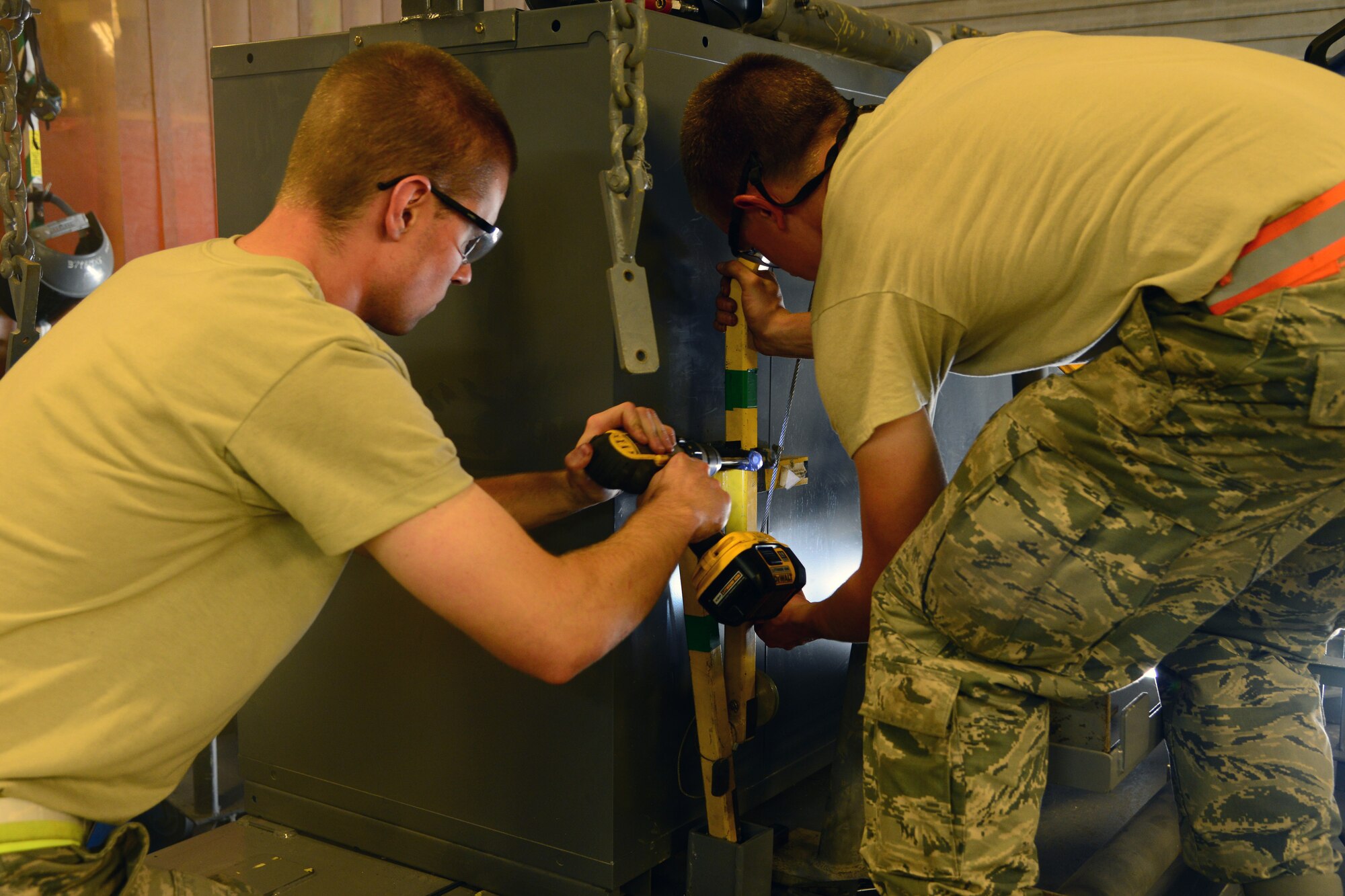 U.S. Air Force Staff Sgt. Cody Leonard and Senior Airman Timothy Dahlstrom, 379th Expeditionary Maintenance Squadron aircraft metals technicians, places brackets on an engine change cart at Al Udeid Air Base, Qatar, Oct. 16, 2014. The new engine change carts will simplify and centralize specialized and normal tools needed to complete a repair. Leonard is deployed from the 185th Air Refueling Wing, Sioux City, Iowa, which is also his hometown. Dahlstrom is deployed from Dyess Air Force Base, Texas, and hails from Northwest, Iowa. (U.S. Air Force photo by Staff Sgt. Ciara Wymbs)