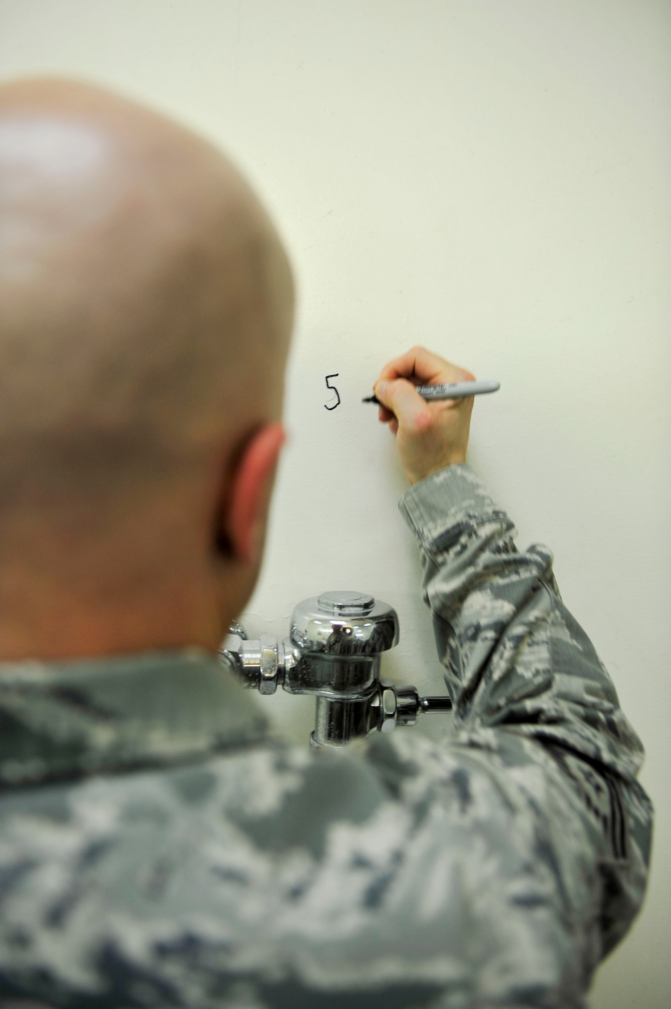 U.S. Air Force Tech. Sgt. Jason Leal, 379th Expeditionary Civil Engineer Squadron utilities asset management program manager numbers each bathroom urinal during an inspection at Al Udeid Air Base, Qatar, Oct. 9, 2014. AUAB has 76 facilities that are beyond or approaching their life expectancy, and the 379 ECES developed a team to extend the service life of these facilities. To execute the short-term repairs, a dedicated four-man team was established and is comprised of an electrician, water fuels system maintenance, heating ventilation and air condition, and structural craftsman. (U.S. Air Force photo by Senior Airman Colin Cates) 
