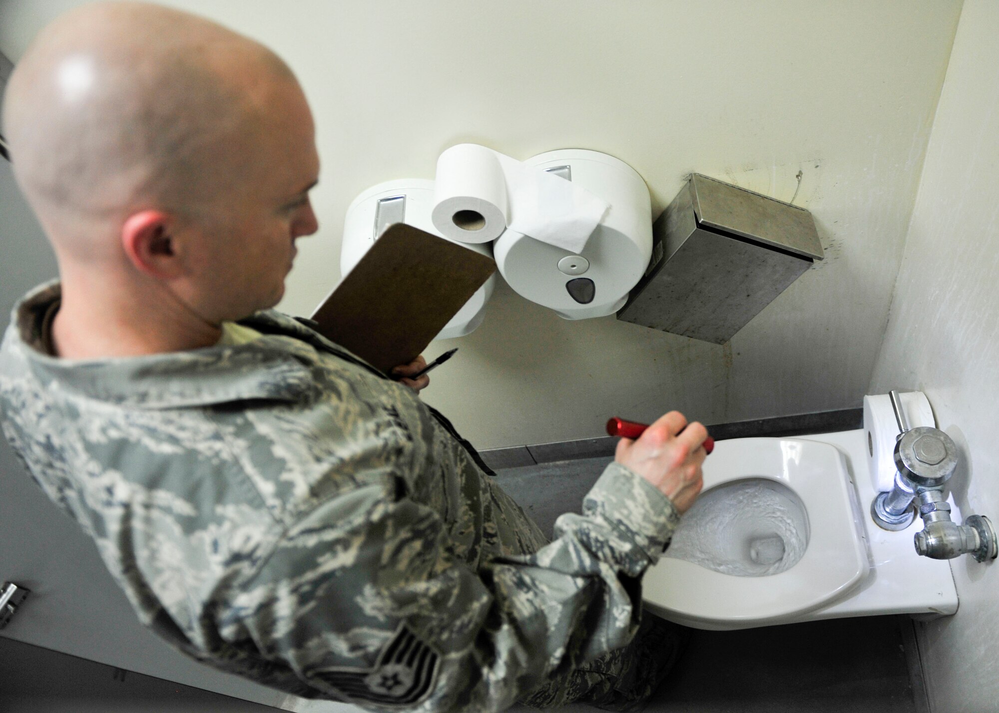 U.S. Air Force Tech. Sgt. Jason Leal, 379th Expeditionary Civil Engineer Squadron utilities asset management program manager inspects the water flow of a toilet at Al Udeid Air Base, Qatar, Oct. 9, 2014. Each facility is put into a red, amber or green category, whereby a red rating implies major overhaul, an amber rating implies minor overhaul or cosmetic repairs, and a green rating implies brand new or minor repairs. To execute the short-term repairs, a dedicated four-man team was established and is comprised of an electrician, water fuels system maintenance, heating ventilation and air condition, and structural craftman. (U.S. Air Force photo by Senior Airman Colin Cates) 
