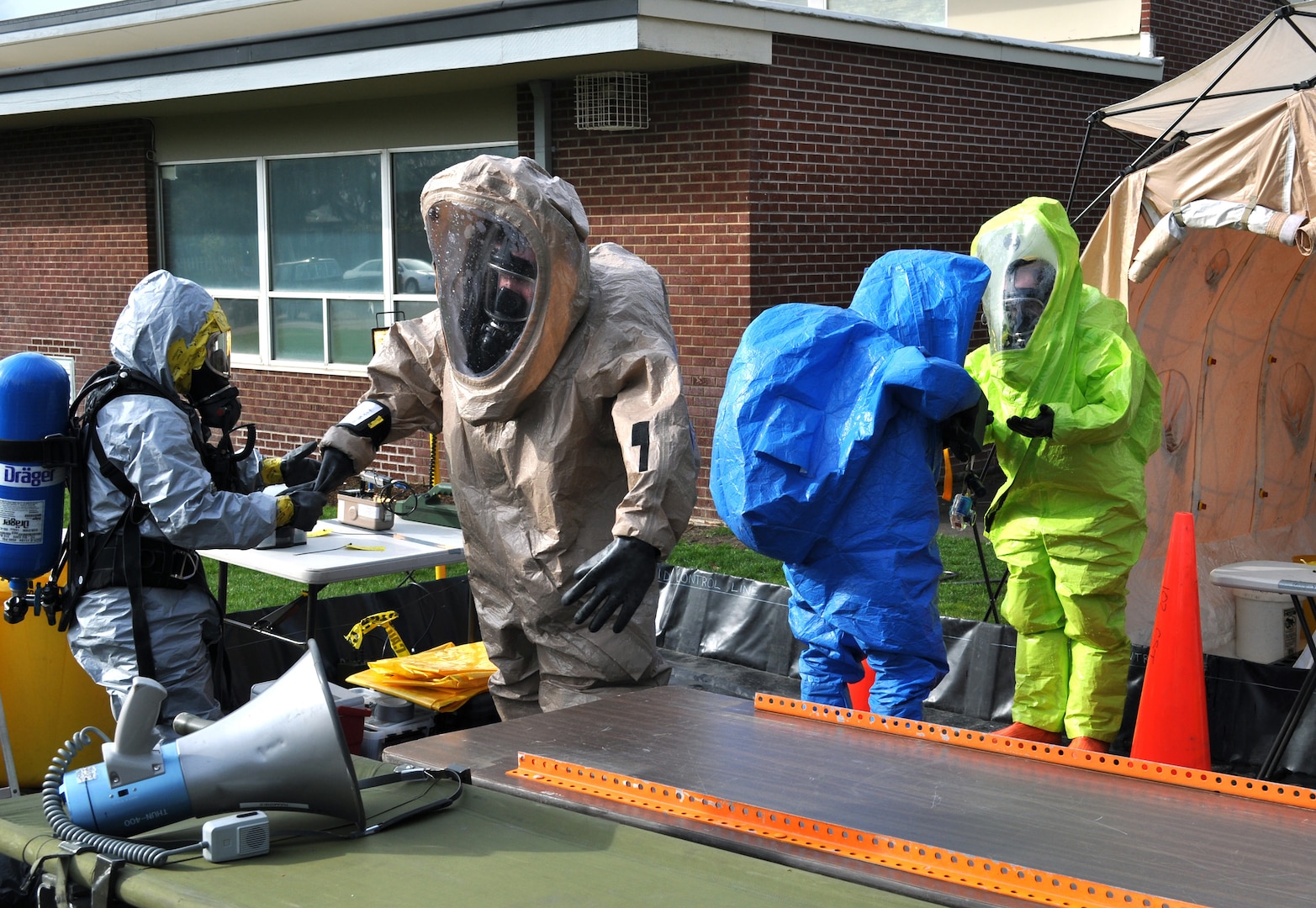 Team members of the 102nd Civil Support Team, Oregon National Guard, conduct a decontamination training and evaluation exercise at the old Silverton High School in Silverton, Oregon, in 2011. Sgt. 1st Class Rowena Simshaw and Staff Sgt. April Henrickx of the Decon Team, 102nd Civil Support Team,  aid in decontaminating other team members.