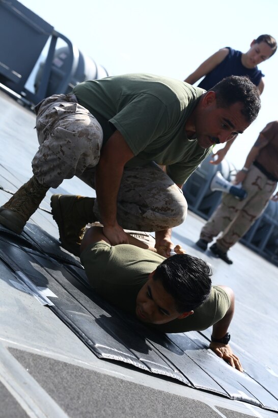 U.S. Navy Hospital Corpsman Chief Petty Officer Juan J. Rivera with Combat Logistics Battalion 11, 11th Marine Expeditionary Unit (MEU) and native of Brooklyn, New York, restrains a simulated protestor during an Oleoresin Capsicum (OC) spray, also known as pepper spray, and nonlethal weapons qualification course aboard the USS San Diego (LPD 22), Oct. 10. The 11th MEU is a forward-deployed, flexible sea-based Marine Air-Ground Task Force embarked with the Makin Island Amphibious Ready Group in the U.S. 5th Fleet area of responsibility. (U.S. Marine Corps photo by Cpl. Jonathan R. Waldman/Released)