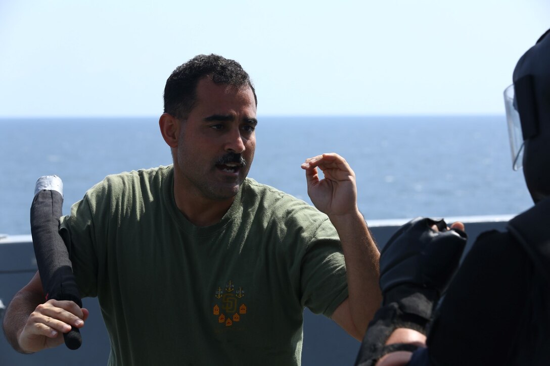 U.S. Navy Hospital Corpsman Chief Petty Officer Juan J. Rivera with Combat Logistics Battalion 11, 11th Marine Expeditionary Unit (MEU) and native of Brooklyn, New York, uses a baton to subdue a simulated protestor during an Oleoresin Capsicum (OC) spray, also known as pepper spray, and nonlethal weapons qualification course aboard the USS San Diego (LPD 22), Oct. 10. The 11th MEU is a forward-deployed, flexible sea-based Marine Air-Ground Task Force embarked with the Makin Island Amphibious Ready Group in the U.S. 5th Fleet area of responsibility. (U.S. Marine Corps photo by Cpl. Jonathan R. Waldman/Released)