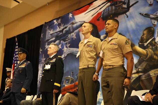 (ret.) Lt. Col. Dean Hunter, honoree, Maj. Gen. Lawrence A. Haskins, Commander, 40th Infantry Division, California Army National Guard, Sgt. Douglas Lockard, platoon sergeant, Combat Logistics Battalion 7, and Cpl. Daniel Kinney, ground radio technician, CLB-7, stand at attention for the playing of the National Anthem and the Marines’ Hymn during the 5th Annual Veterans Expo at the Riverside County Fairgrounds in Indio, Calif., Oct. 11, 2014. The two Marines were chosen from Combat Logistics Battalion 7 to accept recognition for their work.