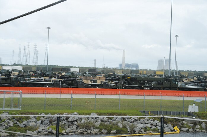 A concrete parking lot at Blount Island Command, Jacksonville, Fla., contains hundreds of military vehicles awaiting shipment to warfighters around the globe. The lot is situated adjacent to the USNS Pfc. Dewayne T. Williams, which is loaded with tons of military vehicles and metal containers.