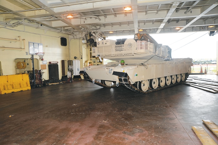 A dockworker drives a tank onto one of several decks on the USNS Pfc. Dewayne T. Williams ship at Blount Island Command, Jacksonville, Fla., recently. The vessel was loaded with tons of critical gear and equipment, which is being transported to Marines as part of operations of the Maritime Prepositioning Force Program.