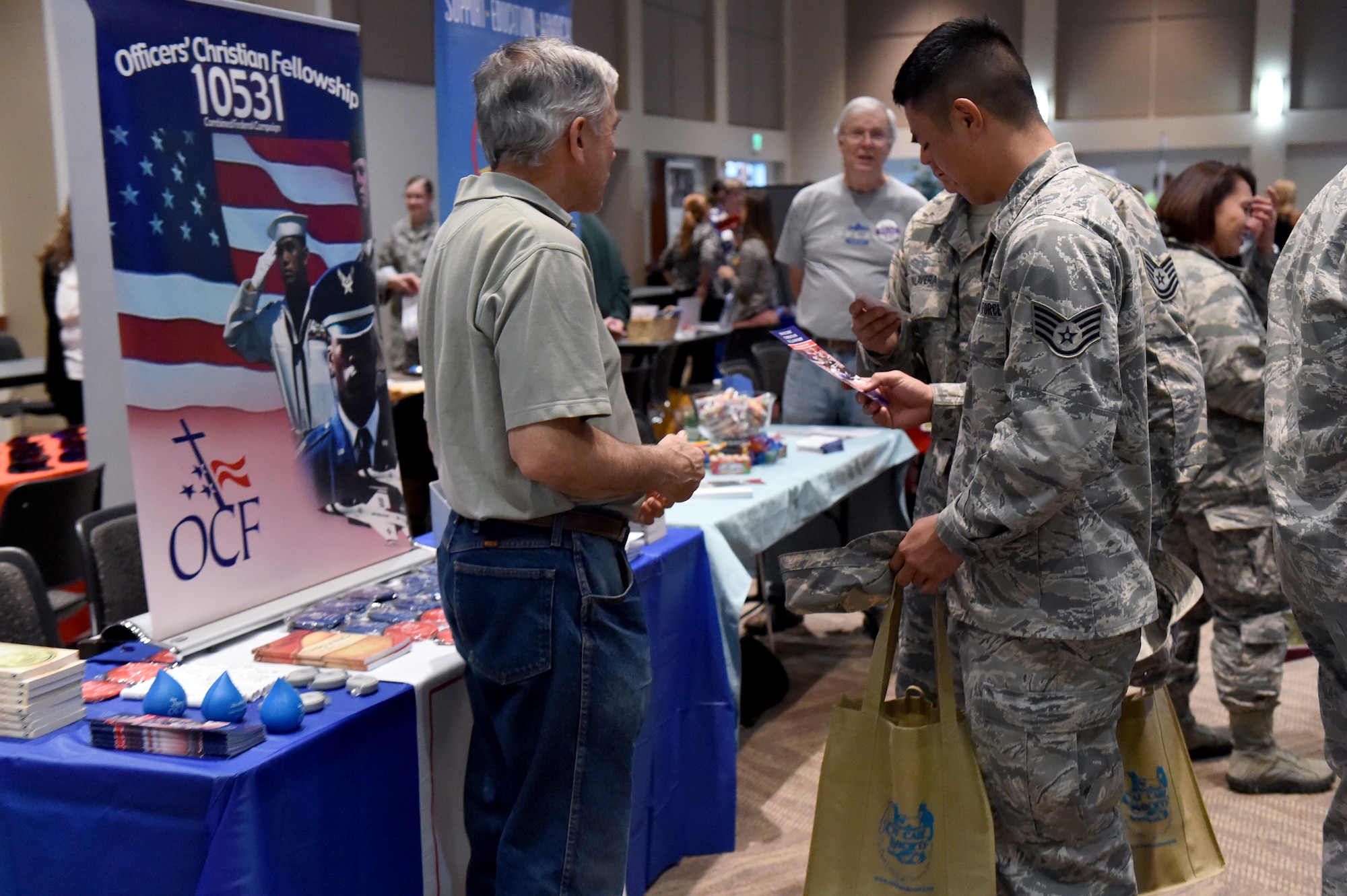 Team Buckley members discuss donating options at the Combined Federal Campaign kickoff event Oct. 15, 2014, at the Leadership Development Center on Buckley Air Force Base, Colo. The CFC is a program that brings local, national and international charities into one combined, easily accessible program that offers federal entities the opportunity to contribute to 20,000 charities worldwide. (U.S. Air Force photo by Airman Emily E. Amyotte/Released)