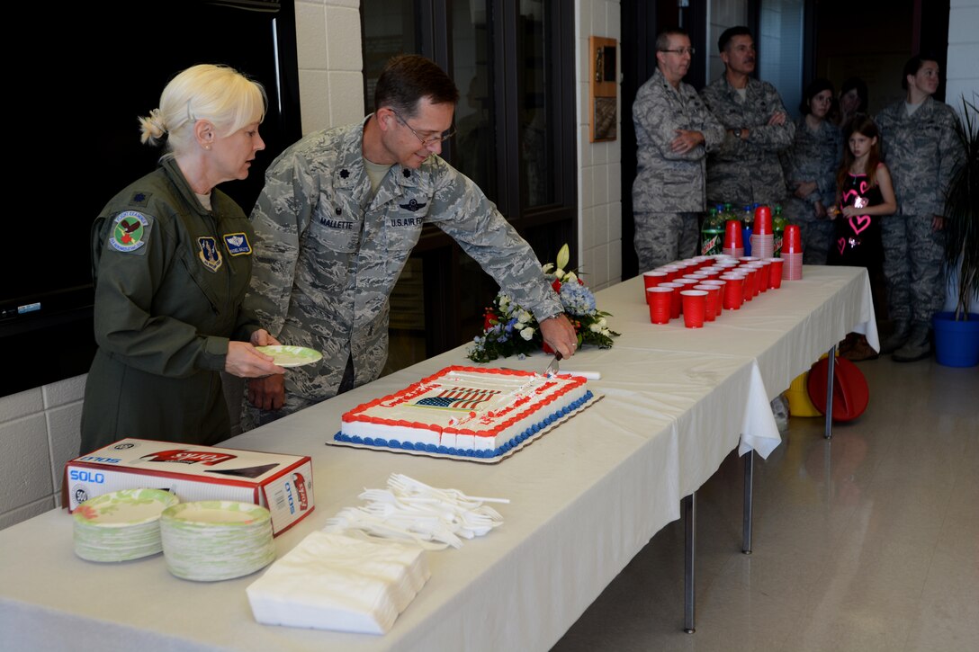 U.S. Air Force Lt. Col. Rachel Mallette, 156th Aeromedical Evacuation Squadron assists her husband, Lt. Col. Stephen Mallette, with cake-cutting duties after his assumption of command ceremony held at the North Carolina Air National Guard base, Charlotte Douglas Intl. Airport, October 4, 2014. Mallette assumed command of the 145th Maintenance Group during October Unit Training Assembly. The Mallettes also have a son, Senior Airman Phillip Mallette, loadmaster for the 156th Airlift Squadron, who is currently deployed. (U.S. Air National Guard photo by Senior Airman Laura Montgomery, 145th Public Affairs /Released)