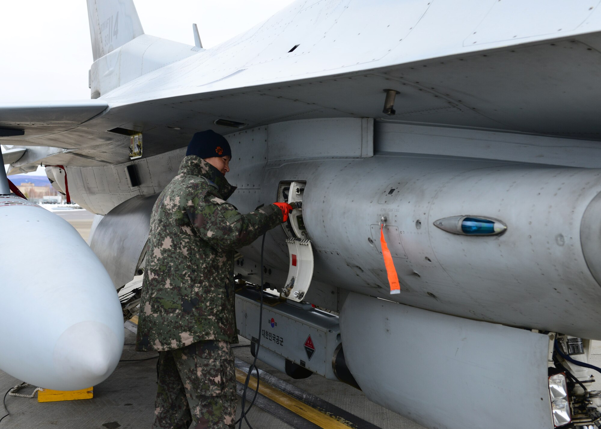Republic of Korea air force Master Sgt. Soo Young Chae, a crew chief assigned to the 120th Aircraft Maintenance Flight, prepares a KF-16D Fighting Falcon fighter aircraft for a sortie at Eielson Air Force Base, Alaska, Oct. 15, 2014, during RED FLAG-Alaska 15-1. RF-A is a series of Pacific Air Forces commander-directed field training exercises for U.S. and partner nation forces, providing combined offensive counter-air, interdiction, close air support and large force employment training in a simulated combat environment. (U.S. Air Force photo by Senior Airman Ashley Nicole Taylor/Released)