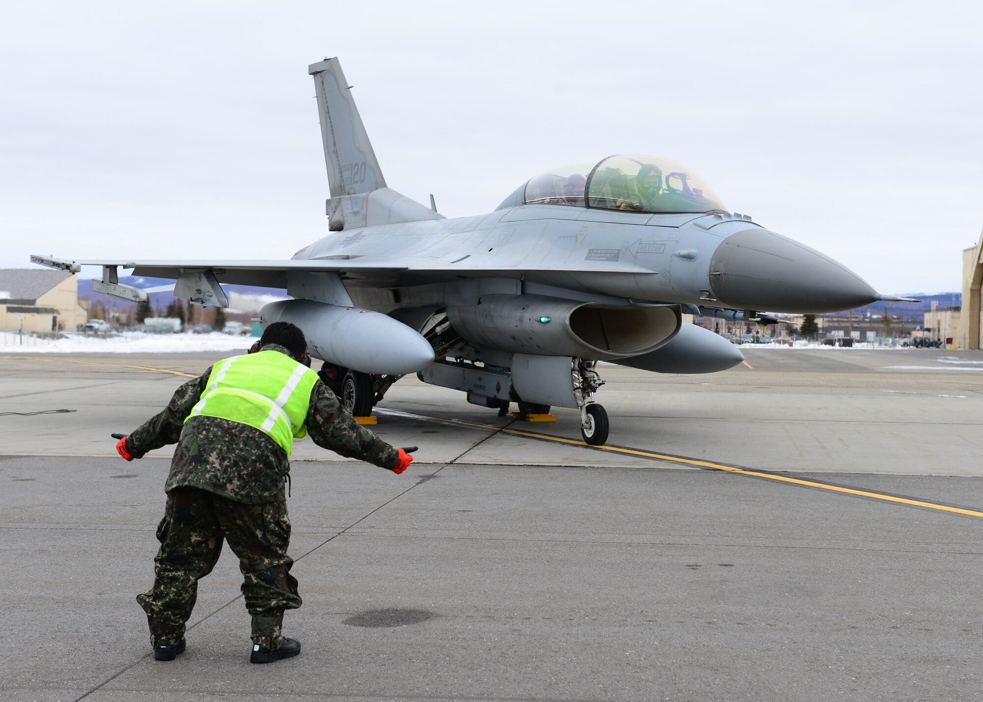 Republic of Korea air force Master Sgt. Soo Young Chae, a crew chief assigned to the 120th Aircraft Maintenance Flight, signals to KF-16D Fighting Falcon fighter aircraft pilots, assigned to the 120th Fighter Squadron, before a sortie at Eielson Air Force Base, Alaska, Oct. 15, 2014, during RED FLAG-Alaska 15-1. RF-A is a series of Pacific Air Forces commander-directed field training exercises for U.S. and partner nation forces, providing combined offensive counter-air, interdiction, close air support and large force employment training in a simulated combat environment. (U.S. Air Force photo by Senior Airman Ashley Nicole Taylor/Released)