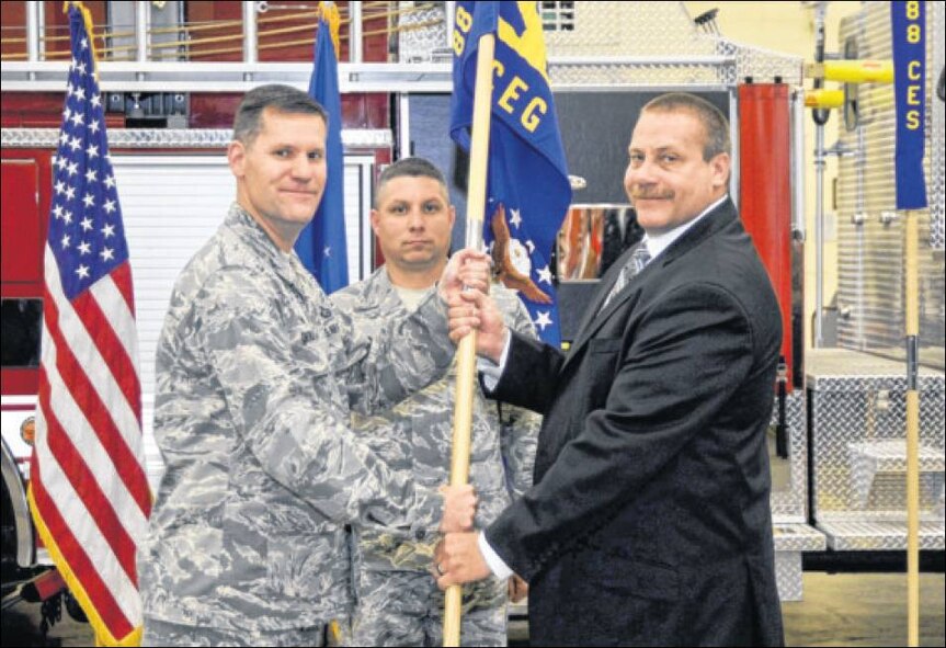 David Perkins assumes the leadership of the 88th Civil Engineer Group by accepting the guidon from Col. John Devillier, 88th Air Base Wing commander, during the unit's activation ceremony at Wright-Patterson Air Force Base on Oct. 9. (Air Force photo by Wesley Farnsworth)