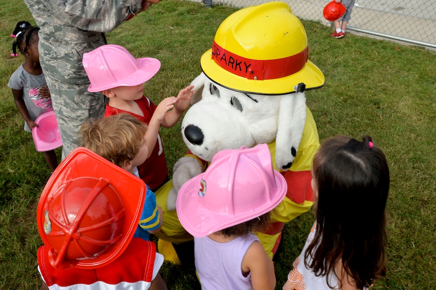 Children interact with Sparky the Fire Dog during National Fire Prevention Week on Barksdale Air Force Base, La., Oct. 8, 2014. Fire Prevention Week is actively supported by fire departments across the country. For 85 years, fire departments have observed Fire Prevention Week, making it the longest running public health and safety observance on record. (U.S. Air Force photo/Airman 1st Class Mozer O. Da Cunha)