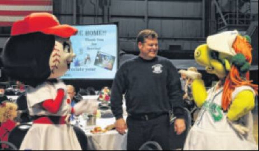 Cincinnati Reds mascot Rosie Red and Dayton Dragons mascot Gem try to win over Don McKay, a firefighter at wright-Patterson Air Force base. (Skywrighter photos by Cindy Holbrook)