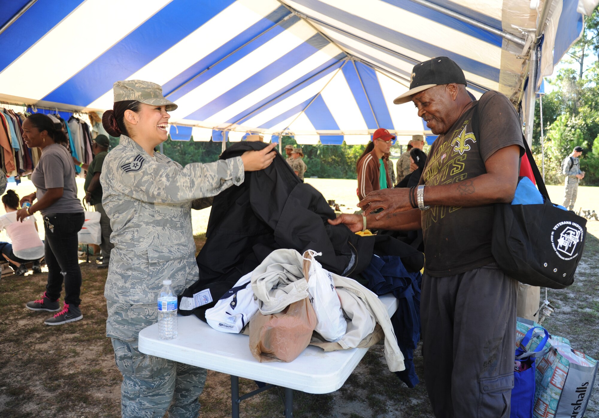 Staff Sgt. Alexandria Mosness, 81st Training Wing, hands a coat to Army veteran Eugene Almon during the 2014 Homeless Veteran Stand Down Oct. 16, 2014, at Hiller Park, Biloxi, Miss The Stand Down, sponsored by VA, local veteran organizations and other community organizations, provided medical services and information to homeless Veterans and families of homeless Veterans. The veterans received medical screenings, flu shots, VA social work services, a hot meal, haircuts, clothing, boots and blankets. Almon served from 1969-1973.  (U.S. Air Force photo Kemberly Groue)