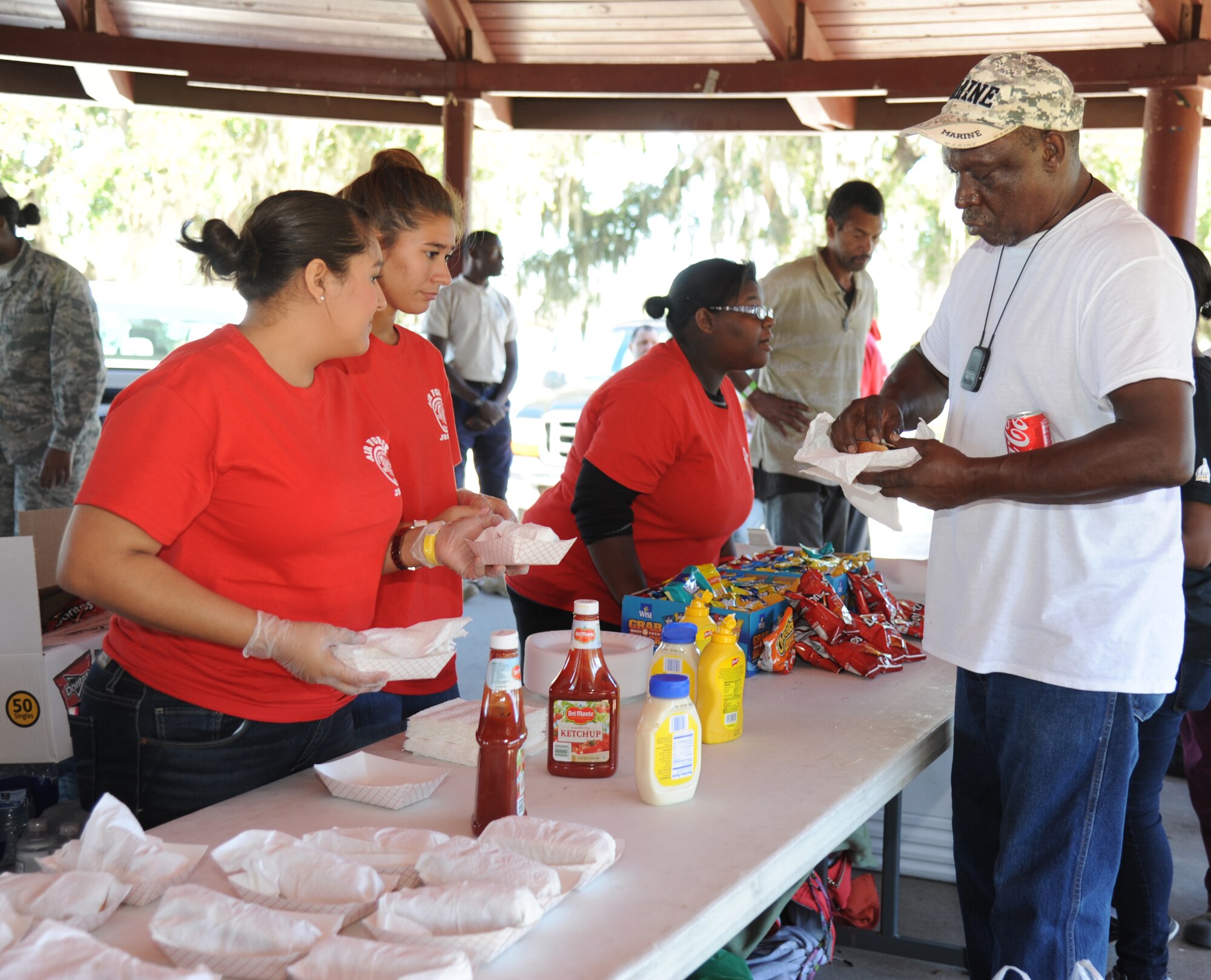 Biloxi Junior ROTC cadets hand out meals to Marine veteran Hilton Sipp during the 2014 Homeless Veteran Stand Down Oct. 16, 2014, at Hiller Park, Biloxi, Miss.  The Stand Down, sponsored by VA, local veteran organizations and other community organizations, provided medical services and information to homeless Veterans and families of homeless Veterans. The veterans received medical screenings, flu shots, VA social work services, a hot meal, haircuts, clothing, boots and blankets. Sipp served from 1973-1978.  (U.S. Air Force photo Kemberly Groue)