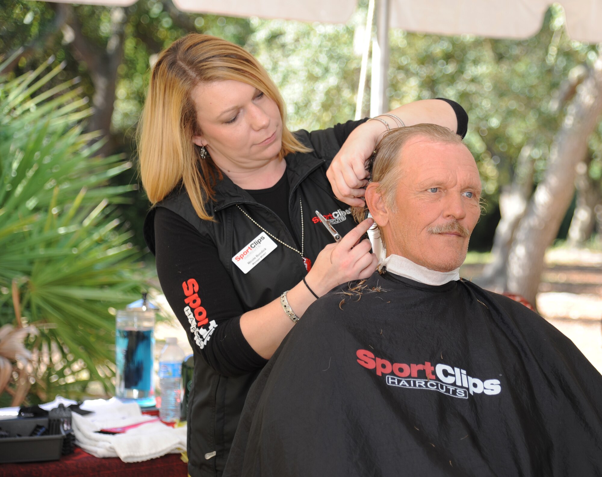 Nicole Bondick, local hair stylist, cuts the hair of Army veteran Ralph Pruitt, during the 2014 Homeless Veteran Stand Down Oct. 16, 2014, at Hiller Park, Biloxi, Miss.  The Stand Down, sponsored by VA, local veteran organizations and other community organizations, provided medical services and information to homeless Veterans and families of homeless Veterans. The veterans received medical screenings, flu shots, VA social work services, a hot meal, haircuts, clothing, boots and blankets. Pruitt served from 1977-1990.  (U.S. Air Force photo Kemberly Groue)