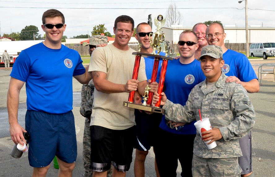 Airmen from the 2nd Civil Engineer Squadron receive the 1st place trophy during the 2014 fire muster on Barksdale Air Force Base, La., Oct. 9, 2014.  Airmen from the 2nd CES won the challenge with a time of 1 minute, 39 seconds, beating seven participating teams. (U.S. Air Force photo/Airman 1st Class Mozer O. Da Cunha)